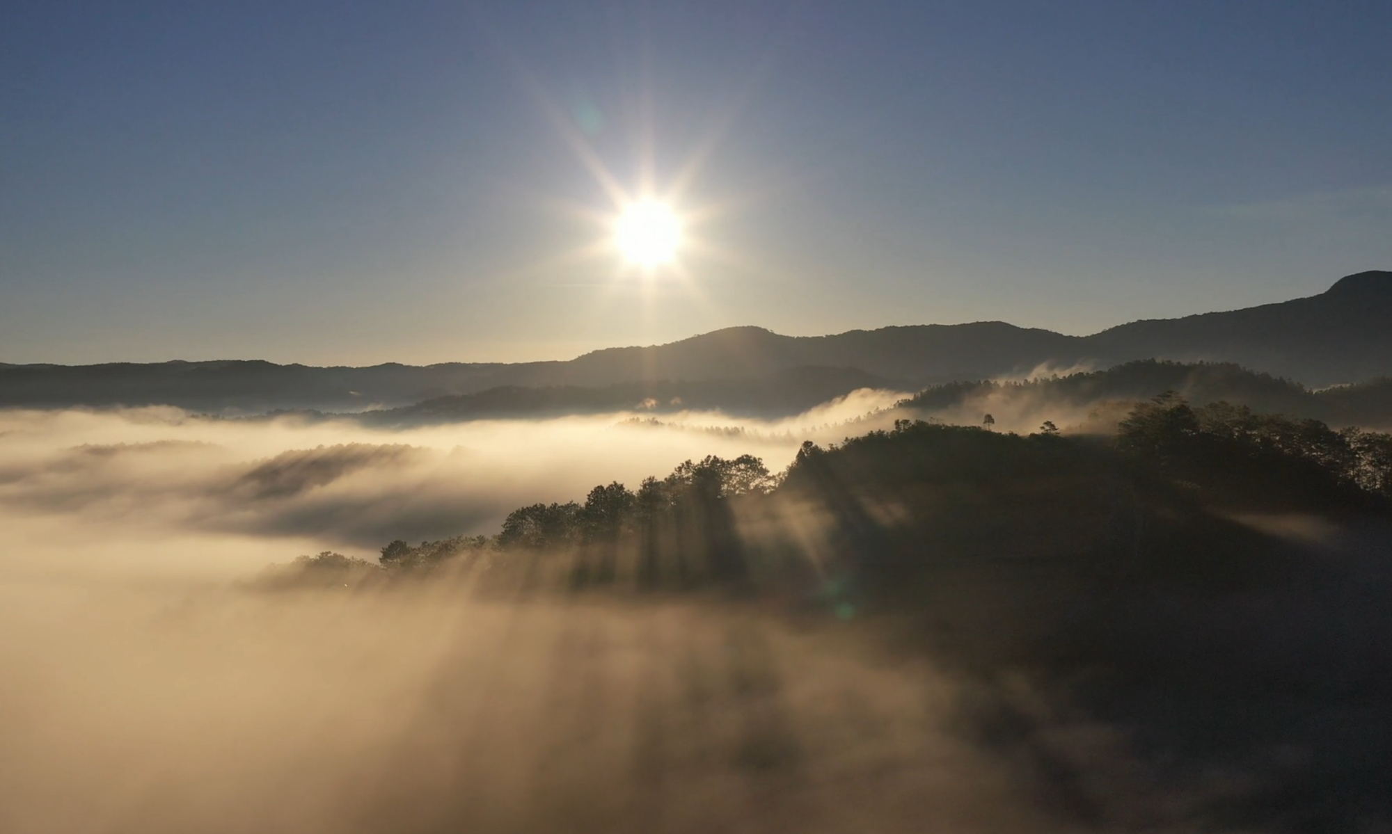 Landschaftsbild mit Nebel im Tal und Sonne in den Bergen